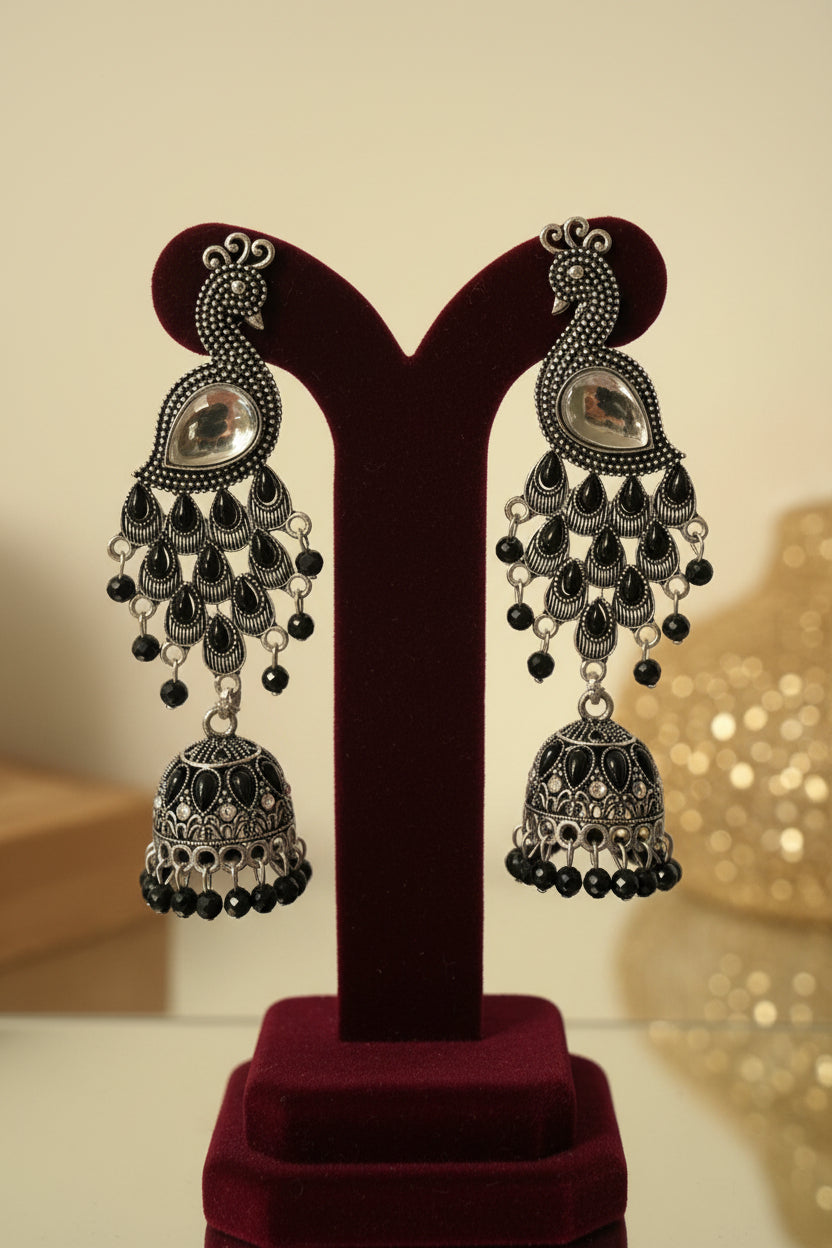 Peacock figure oxidised long earrings with medium size jhumka in the bottom. 