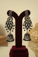 Peacock figure oxidised long earrings with medium size jhumka in the bottom. 