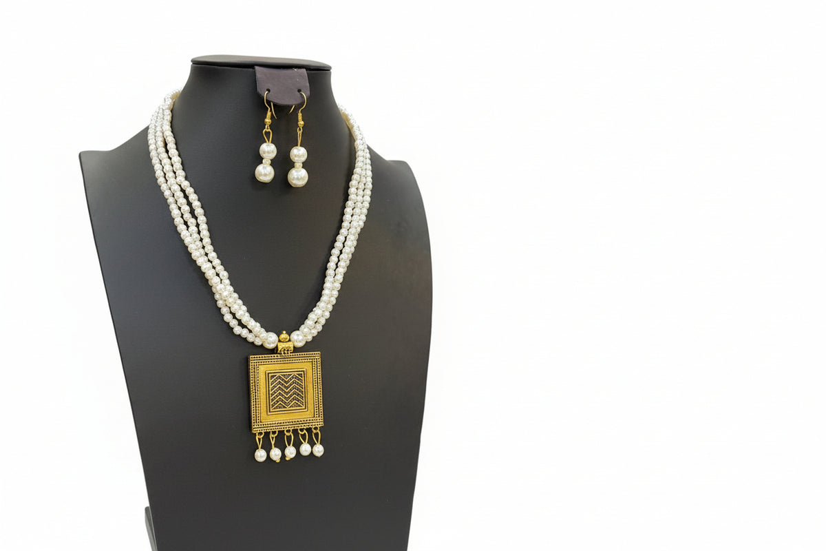 Pearl necklace with gold pendant and matching earrings.