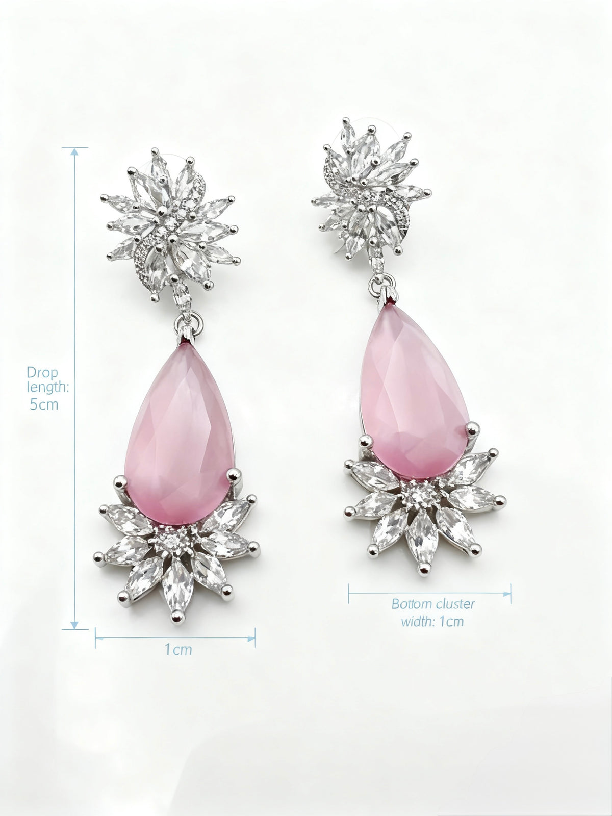 Pink teardrop earrings with silver floral tops on a white background