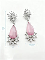 Pink teardrop earrings with silver floral tops on a white background