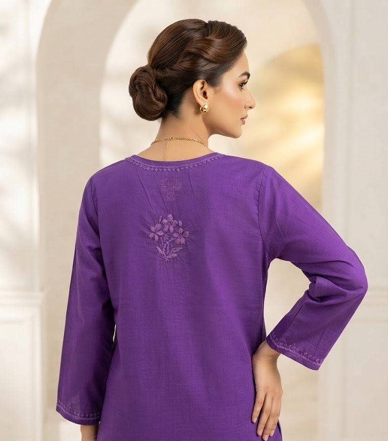 Rear view of a woman wearing a purple cotton short kurti featuring a delicate floral motif embroidered on the back yoke, designed with a square hem line.