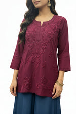 Model wearing a deep plum short kurti featuring intricate leaf embroidery, styled as a standalone short kurti without bottom trousers.