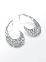 High-angle flat lay photograph of a pair of rhodium-plated statement earrings featuring an intricate floral lattice mesh design encrusted with brilliant White American Diamond (AD) stones on a reflective white surface.