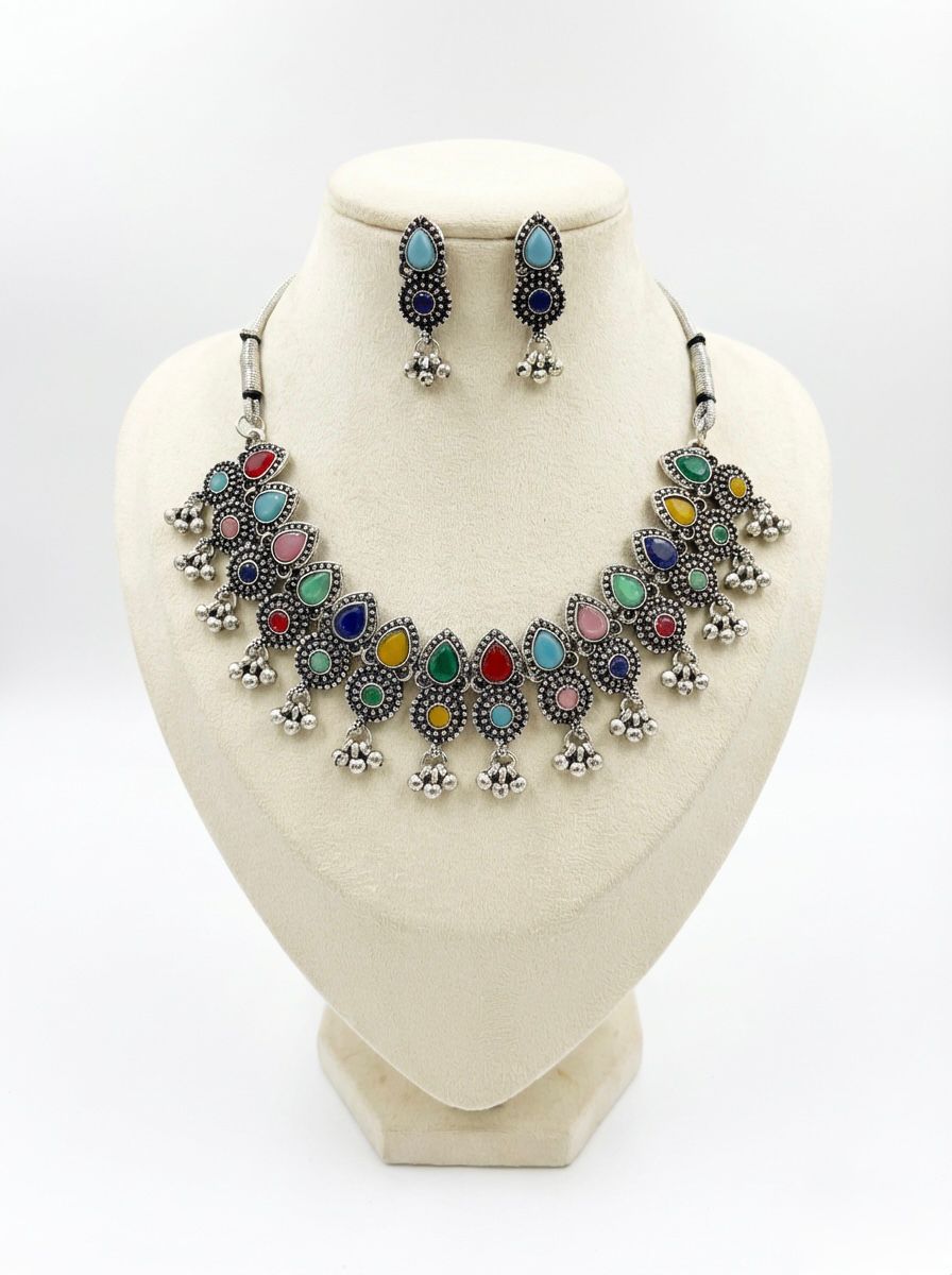 Premium silver oxidised choker set with multicoloured teardrop accents on a display stand, highlighting the high-grade antique polish and intricate alloy craftsmanship.