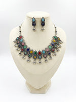 Premium silver oxidised choker set with multicoloured teardrop accents on a display stand, highlighting the high-grade antique polish and intricate alloy craftsmanship.