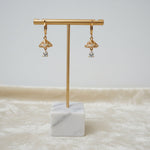 Professional product shot of the rose gold polish white stone earrings on a display stand, highlighting the precision-cut AD stones.