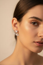 Professional shot of the Amara silver polish heart fringe earrings on a display stand, highlighting the brilliant white American Diamonds.