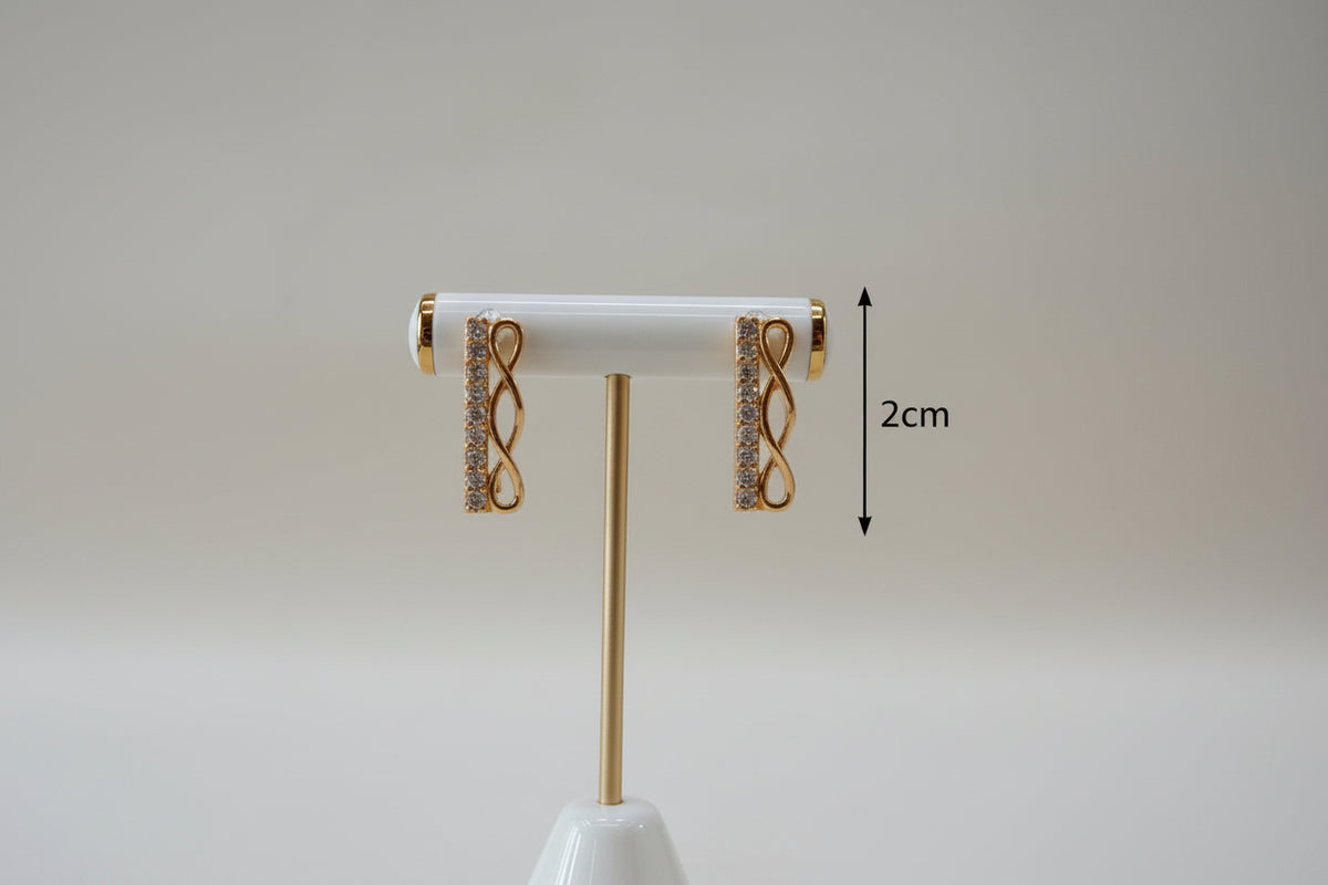 Professional shot of the Aura rose gold polish infinity bar earrings on a display stand, highlighting the brilliant AD stone clarity.