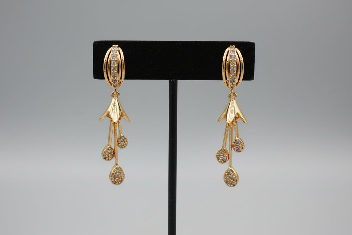 Professional shot of the Kaya rose gold polish triple teardrop earrings on a display stand, highlighting the movement of the AD charms.