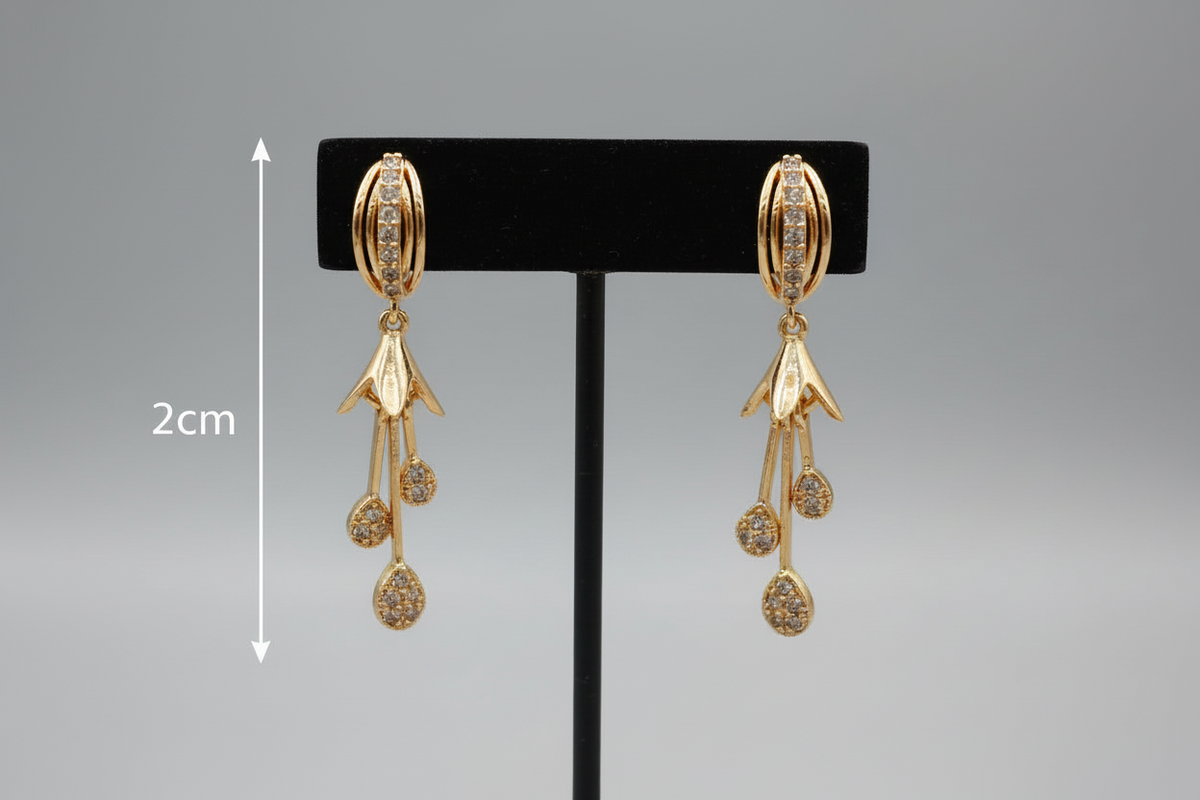 Gold earrings on a black stand with measurement label on a gray background
