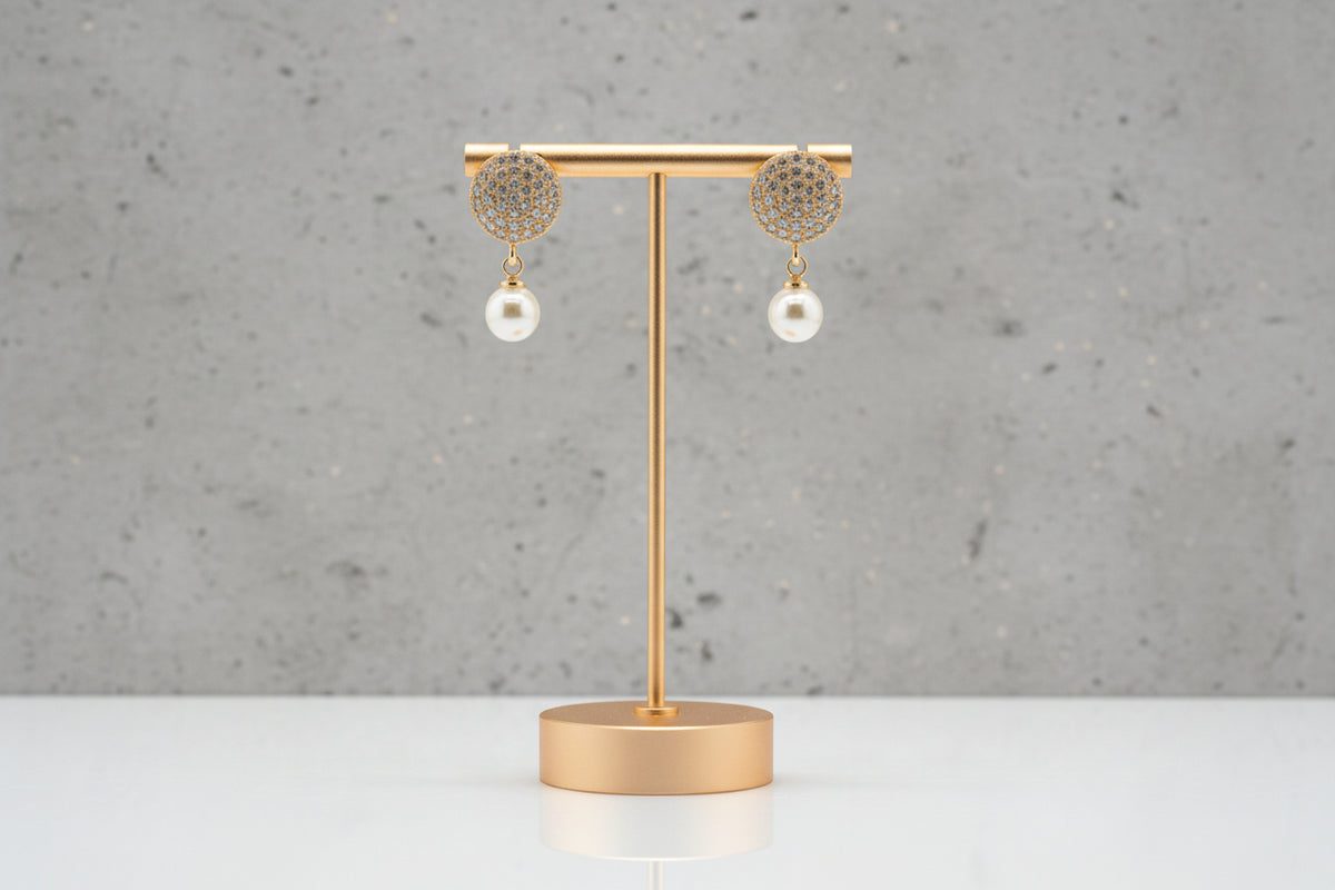 Professional shot of the Serene rose gold polish pearl drop earrings on a display stand, highlighting the brilliant stone clarity.