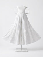 White tiered cotton sharara with detailed Chikankari embroidery on a display stand.