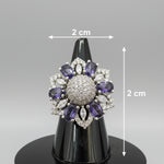 Silver-tone floral halo ring with oval purple stones, round American diamond center, and marquise clear accents.