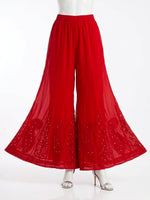 Red georgette gharara with intricate chikankari embroidery and mukaish detailing, wide flared design, displayed on stand.