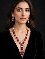Model wearing regal ruby red pear & cushion-cut gemstone necklace with matching statement earrings, gold-tone finish with sparkling clear crystal accents — South Asian bridal & formal jewelry.