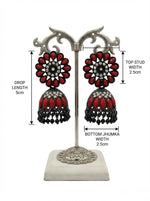 Rich black brass jhumka earrings adorned with a deep maroon floral stone stud and matching maroon stone embellishments.