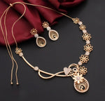 Rose Gold-toned jewellery set with nano American diamond stones featuring a necklace, matching earrings, and a waist chain, decorated with floral and paisley motifs, displayed on a dark background with a draped maroon fabric.
