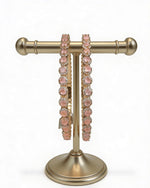 Rose Gold bracelets displayed on a stand. 