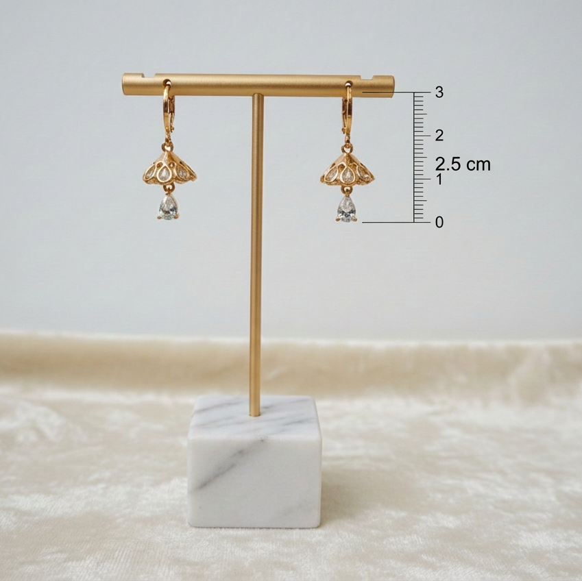Rose Gold earrings on a marble stand with measurement scale against a light background