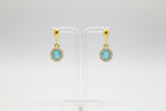 Rose Gold earrings with blue stones with pure white background. 
