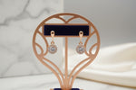 Rose Gold earrings with clear stones on a blue earrings card displayed. 