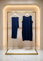 Hanging display of the navy blue handcrafted sleeveless Chanderi silk Chikankari co-ord set, featuring the tunic and matching trousers hanging side-by-side on white hangers within a gold boutique rack.