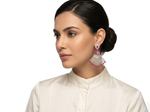 Woman wearing pink and silver earrings on a white background