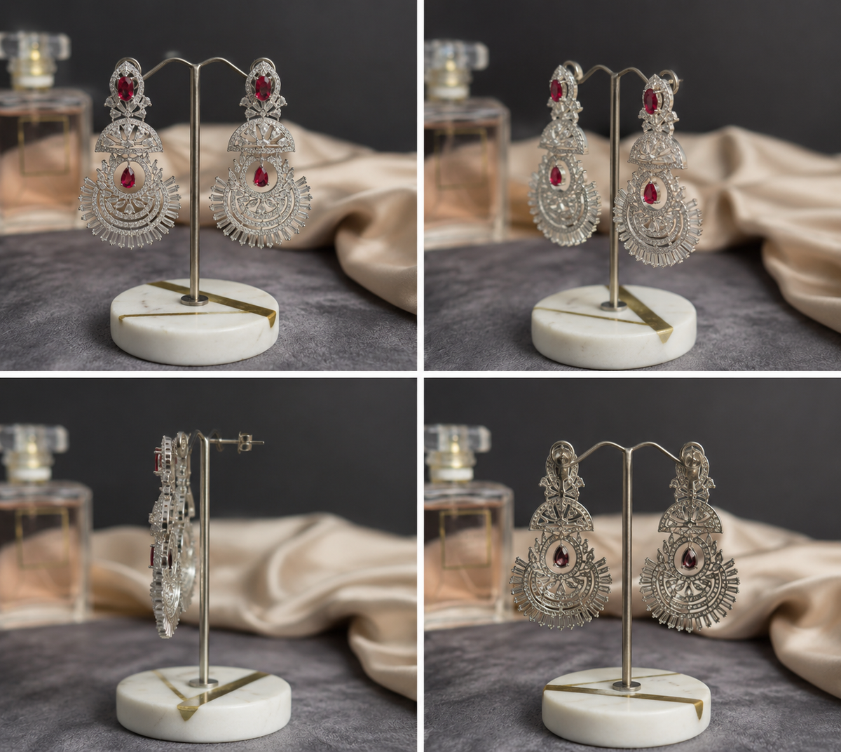 Luxury silver-tone chandelier earrings with ruby red stones displayed on a jewelry stand, featuring intricate filigree detailing and sparkling crystal accents.