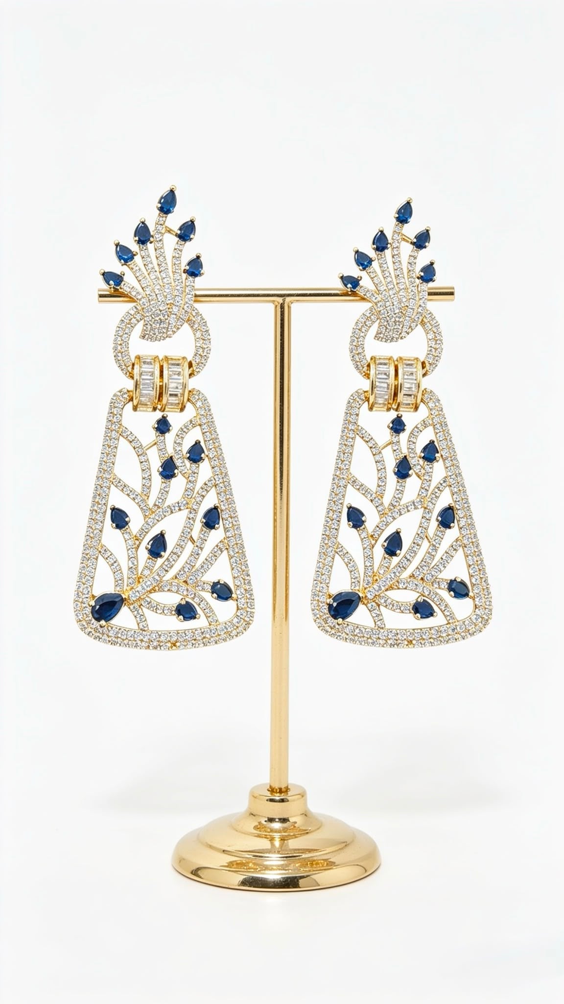 Pair of silver-toned dangle earrings with royal blue stone embellishments and American Diamond lattice detailing on a posh display stand.