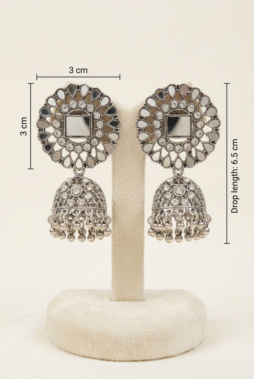 Silver-toned Indian jhumka earrings displayed on a cream-colored jewelry stand, with dimension lines indicating a 3 cm circular size and 6.5 cm drop length.