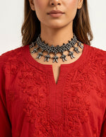 Close-up view of the neckline and detailed floral embroidery on a vibrant red short kurti, styled as a standalone short kurti without bottom trousers.