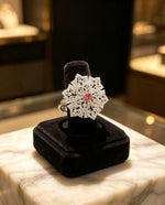 Elegant Silver & Pink American Diamond Ring — Luxury Collection by Famaza Couture, snowflake halo design, displayed on black velvet ring stand over marble surface.