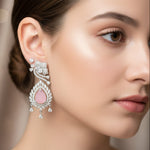 Silver-toned American Diamond drop earrings featuring a tear-drop shaped pink sugar stone with carved floral details.