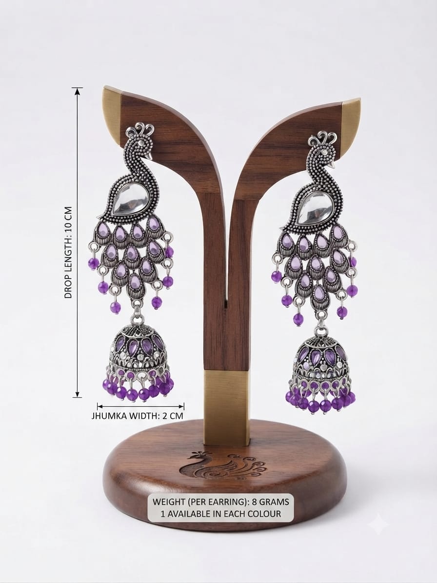 Silver-toned and purple jhumka earrings displayed on a wooden stand with measurement annotations showing drop length of 10 cm and jhumka width of 2 cm.