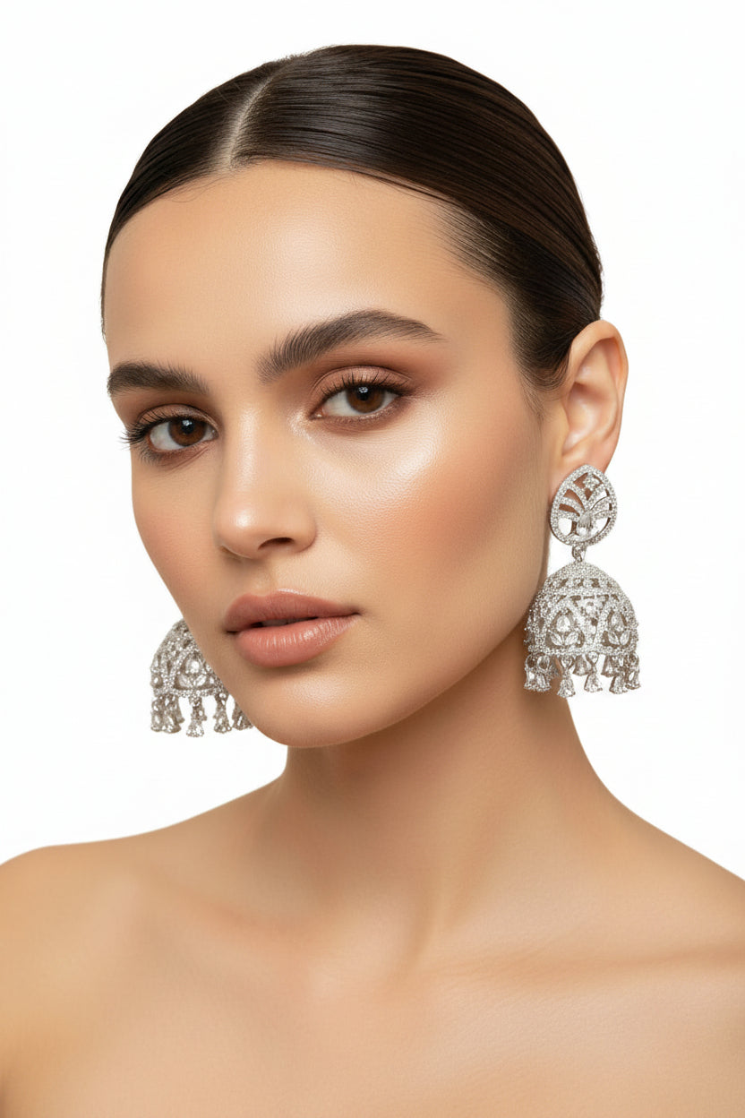 Silver-toned bridal Jhumka earrings with high-shine crystal worn by our model.