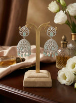 Silver-toned bridal Jhumka earrings with high-shine ice blue crystal encrustation and hanging crystal droplets on a display stand.