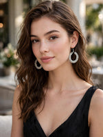 Model wearing silver crystal-encrusted teardrop hoop earrings with fishhook closure — Famaza Couture bridal & festive luxury jewelry.