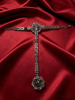 Back view of silver plated AD stone hathphool hand harness — floral bracelet connected to adjustable ring, intricate stone-set chain design, flat lay on rich red satin fabric, premium Pakistani bridal jewelry.