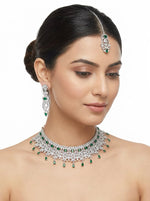 Silver plated bridal jewelry set – emerald green stones, cubic zirconia, necklace, earrings and maang tikka – worn by model.