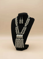 Oxidised long necklace and drop earrings on a black dummy with a blurred background