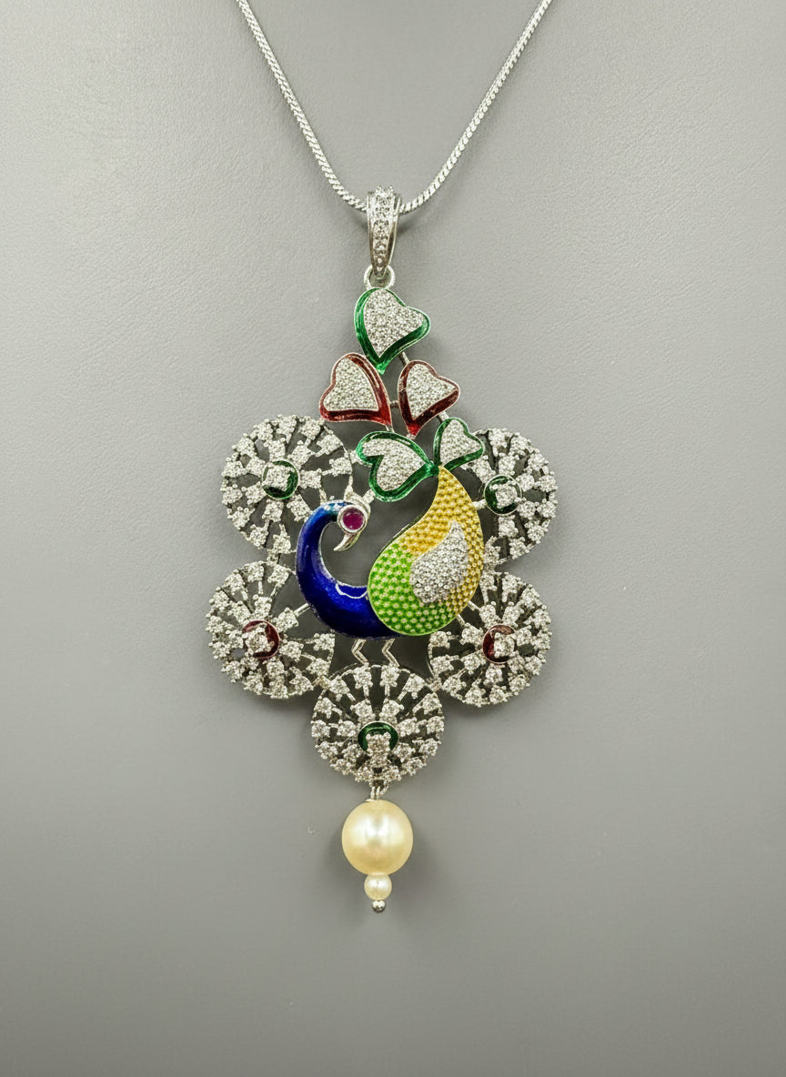 Silver polished a peacock pendant with vibrant green, blue, and gold enamel accents, along with white AD stones sparkling embellishments. Pendant is focused to show the design.