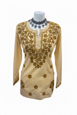 Creamy beige cotton short kurti featuring intricate dark yellow-brown floral embroidery along the neckline and scattered motifs across the front, displayed on a mannequin.