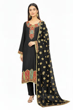 Model wearing a black silk kurta set with intricate Kanni embroidery and zari work, paired with a Banarasi chiffon dupatta and raw silk trousers, set against a pure white background.