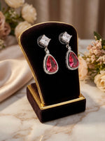 Teardrop-shaped earrings with hot pink stone and white stone earrings. 