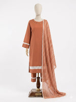 A front studio photograph of a three-piece terracotta plain cotton shalwar kameez suit by Famaza Couture, displayed on a wooden mannequin stand against a solid white background. The outfit features a solid terracotta straight kurta with a detailed neckline pattern and white lace insert trims on the sleeves and hemline, matching trousers with pintuck folds and white lace borders, and a coordinating lightweight patterned sheer dupatta draped neatly over the left shoulder.