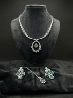  The American diamonds bridal jewellery set including necklace, earrings and maang tikka with Turquoise colour central cubic zirconia stones. 