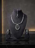  The American diamonds bridal jewellery set including necklace, earrings and maang tikka with black central cubic zirconia stones. 