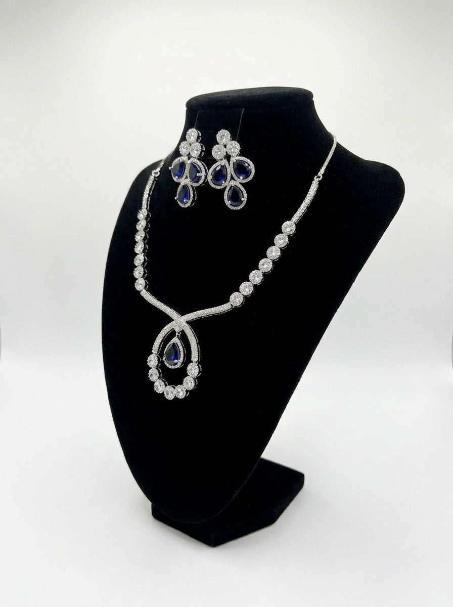 The American diamonds bridal jewellery set including necklace, earrings and maang tikka with purple colour central cubic zirconia stones. 
