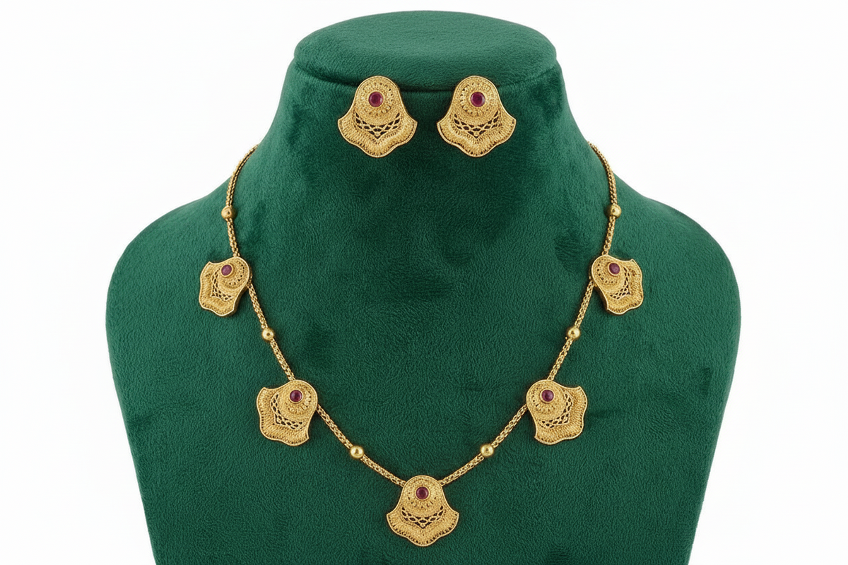 The Antique gold brass metal necklace and stud earrings with ruby red central stones. 